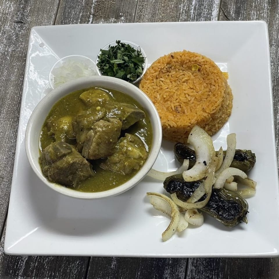 Pork in green chile sauce, Mexican rice, grilled peppers and onions, with sides of cilantro and diced onions.